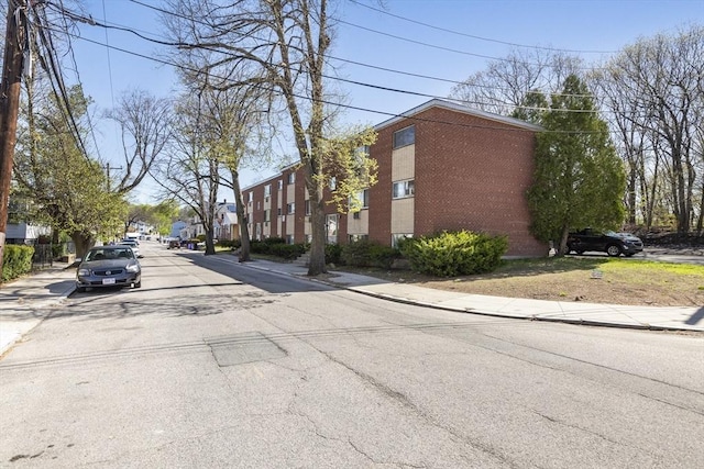 view of asphalt road with sidewalks and curbs