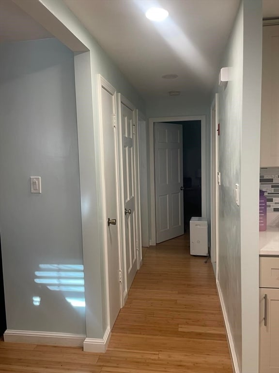 hallway with light hardwood / wood-style flooring