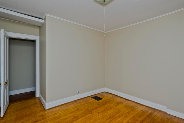 unfurnished room with wood-type flooring and ornamental molding