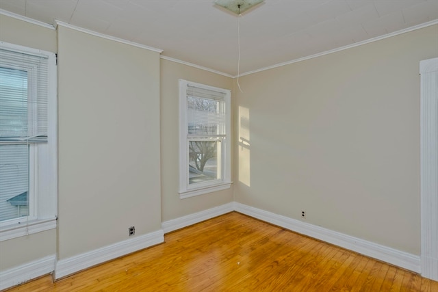 empty room with wood-type flooring and ornamental molding