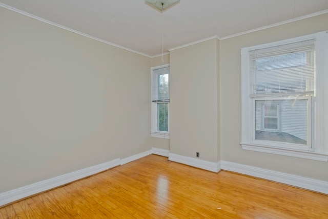 unfurnished room featuring crown molding, a healthy amount of sunlight, and wood-type flooring