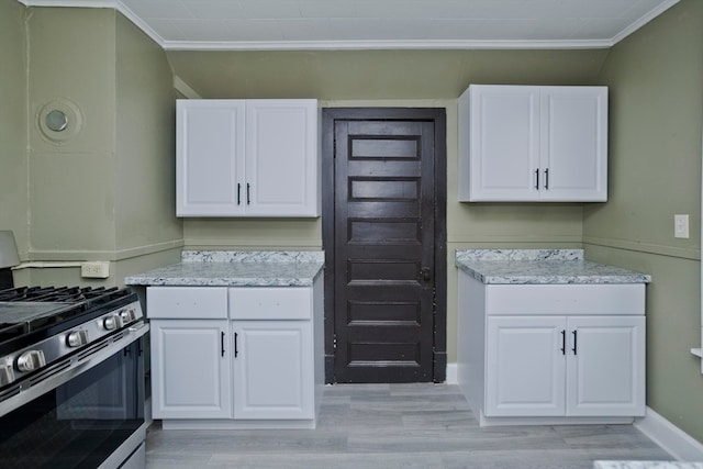 kitchen featuring white cabinetry, stainless steel range with gas cooktop, ornamental molding, and light hardwood / wood-style flooring