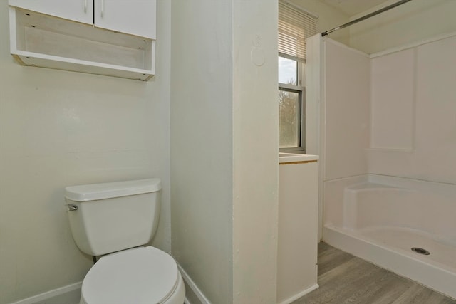 bathroom with a shower, wood-type flooring, and toilet