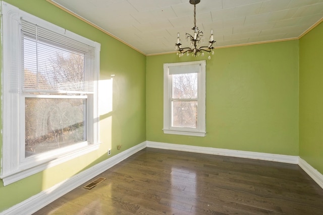 unfurnished dining area with dark hardwood / wood-style floors, a wealth of natural light, and a chandelier