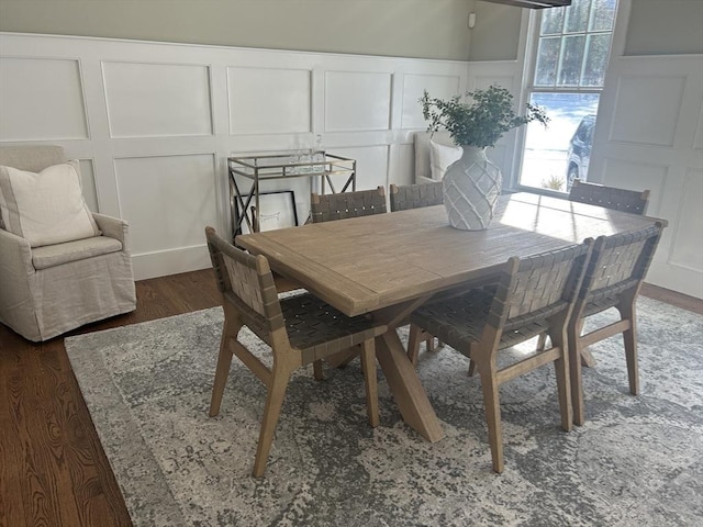 dining area with a decorative wall and wood finished floors