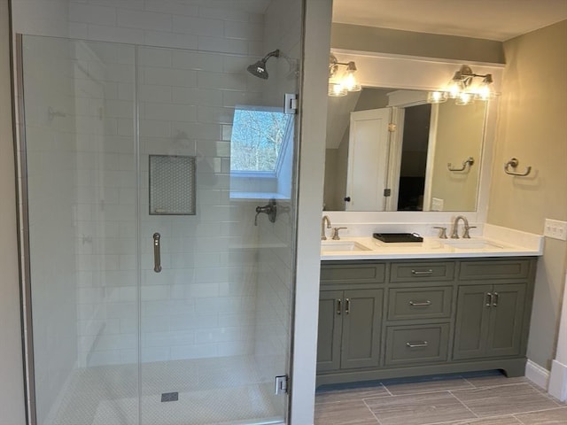 bathroom with a shower stall, double vanity, and a sink