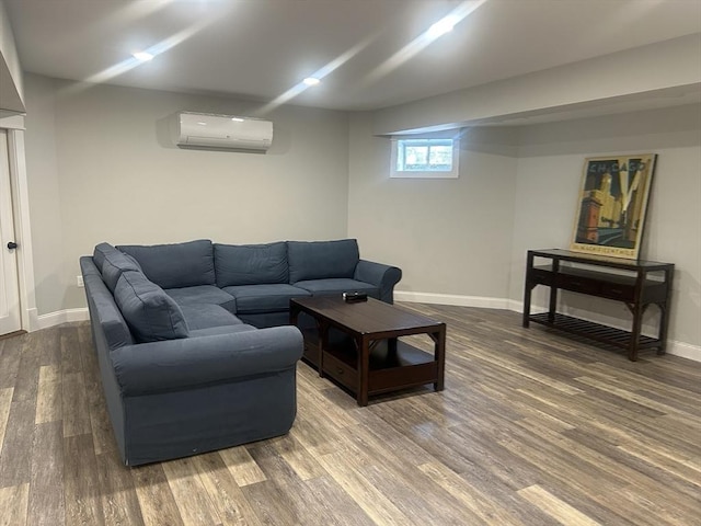 living area with baseboards, wood finished floors, and a wall unit AC