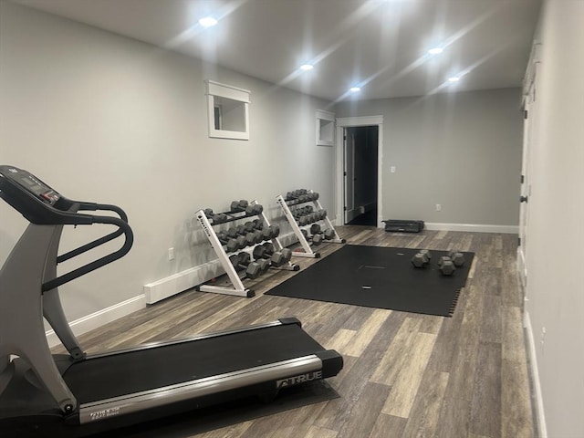 exercise area featuring baseboards and wood finished floors