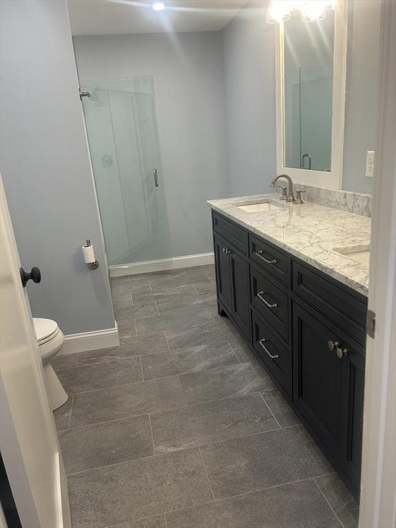 bathroom featuring a sink, baseboards, and a stall shower