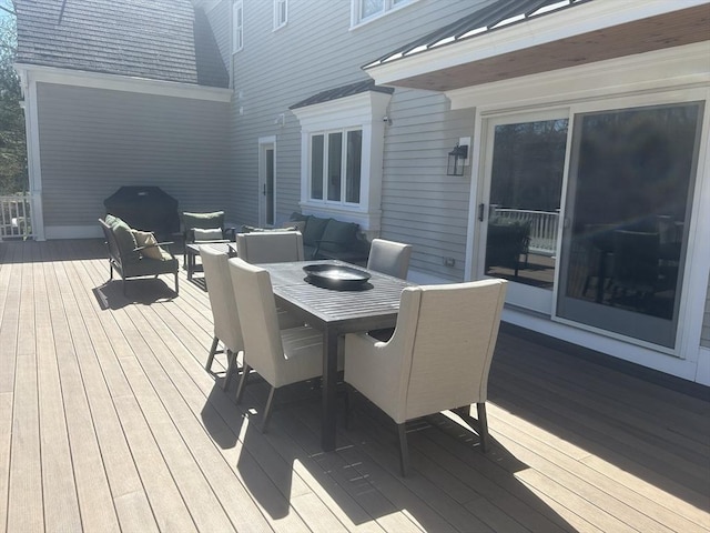 deck with outdoor dining area and a grill