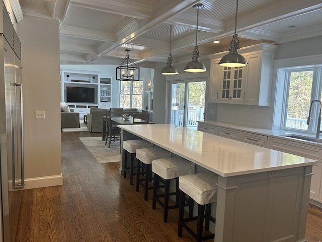 kitchen with plenty of natural light, dark wood-style floors, a sink, and beam ceiling