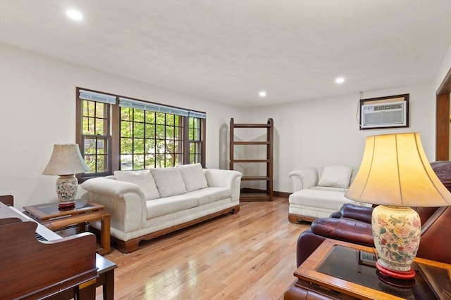 living room with a wall mounted air conditioner, light wood-style floors, and recessed lighting