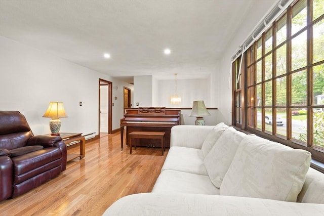 living area with recessed lighting, light wood-style floors, a baseboard heating unit, and baseboards