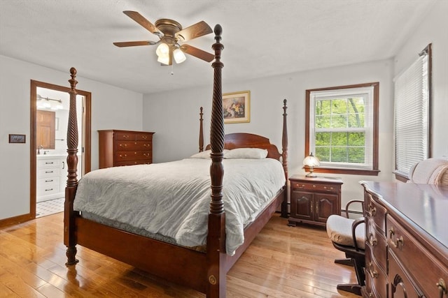 bedroom with light wood-type flooring, a baseboard radiator, ceiling fan, and connected bathroom