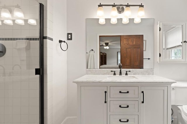 full bathroom featuring vanity, a shower stall, toilet, and a ceiling fan
