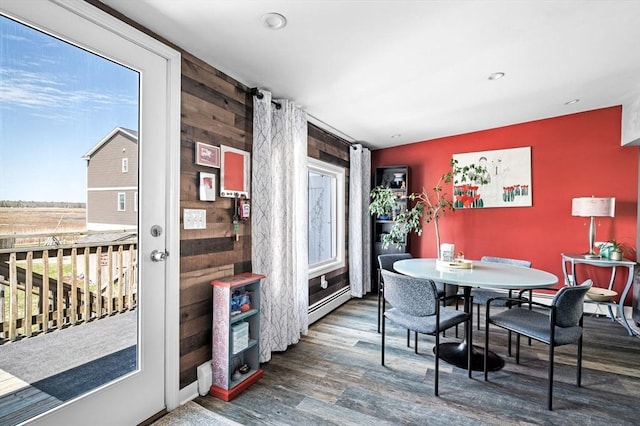 67 N End Blvd Unit 1, Salisbury, MA 01952 - dining room featuring wood finished floors, an accent wall, wood walls, a baseboard radiator, and recessed lighting