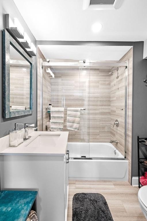 67 N End Blvd Unit 1, Salisbury, MA 01952 - full bath featuring vanity, toilet, shower / bath combination with glass door, and wood finished floors