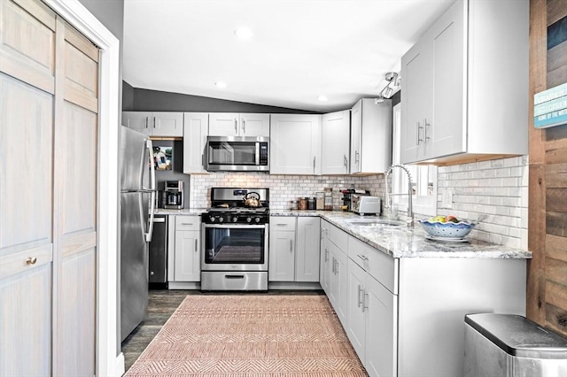 67 N End Blvd Unit 1, Salisbury, MA 01952 - kitchen featuring stainless steel appliances, wood finished floors, lofted ceiling, backsplash, and light stone counters