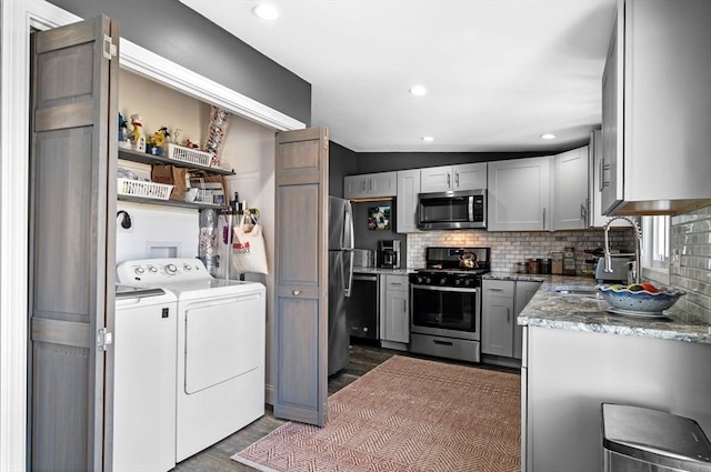 67 N End Blvd Unit 1, Salisbury, MA 01952 - kitchen featuring appliances with stainless steel finishes, washer and clothes dryer, dark wood-style floors, tasteful backsplash, and recessed lighting