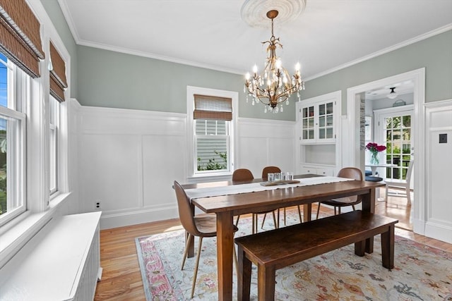 32 Oneida Rd, Winchester, MA 01890 - dining space with light wood finished floors, ornamental molding, a chandelier, a decorative wall, and a wainscoted wall