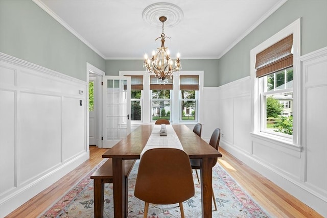 32 Oneida Rd, Winchester, MA 01890 - dining area with a decorative wall, light wood-type flooring, healthy amount of natural light, a chandelier, and crown molding