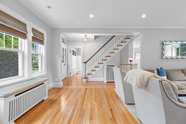 32 Oneida Rd, Winchester, MA 01890 - living room featuring radiator heating unit, crown molding, light wood-type flooring, recessed lighting, and stairs