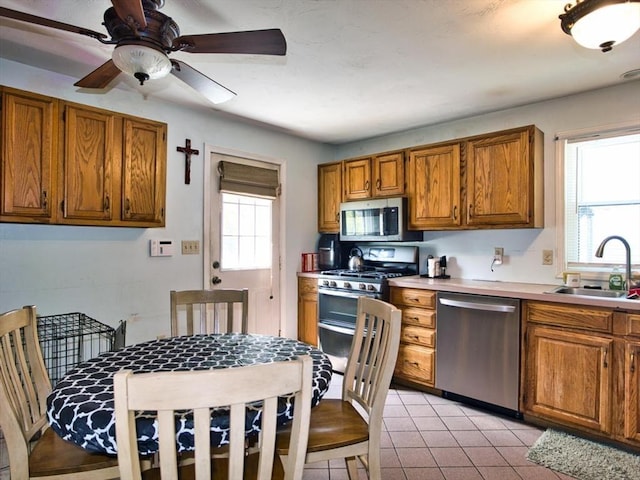56 Gatehouse Dr, Fall River, MA 02720 - kitchen with stainless steel appliances, a sink, brown cabinets, and ceiling fan