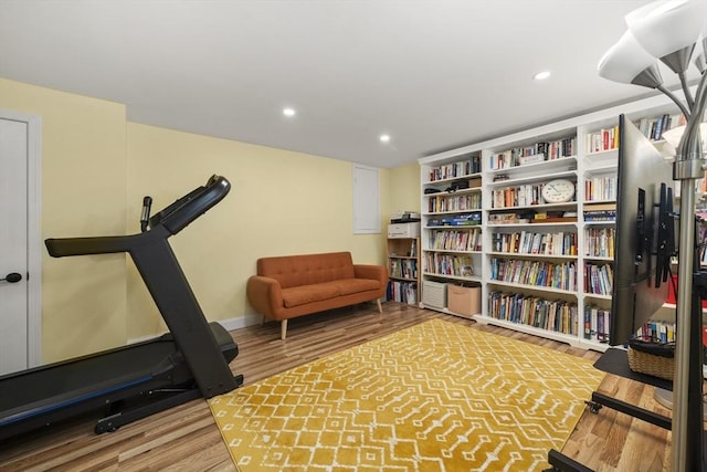 workout area featuring wood finished floors, recessed lighting, and baseboards