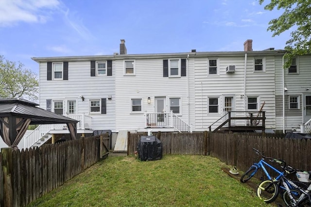 back of house with a gazebo, a wall unit AC, and a chimney