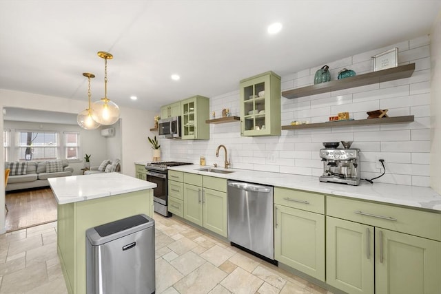 kitchen with green cabinets, stainless steel appliances, open shelves, a sink, and decorative backsplash