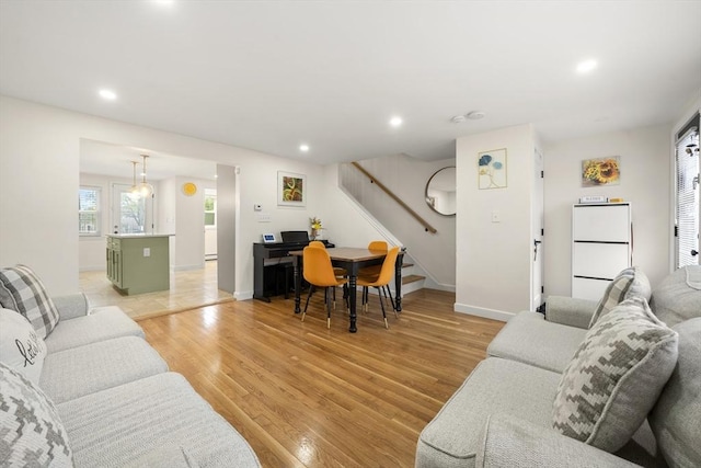 living area featuring stairway, light wood-style floors, recessed lighting, and baseboards