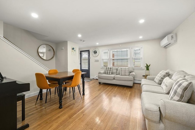 living room with a wall mounted AC, light wood-style floors, baseboard heating, recessed lighting, and baseboards