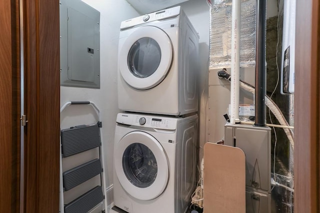 laundry room with laundry area, electric panel, and stacked washer / drying machine