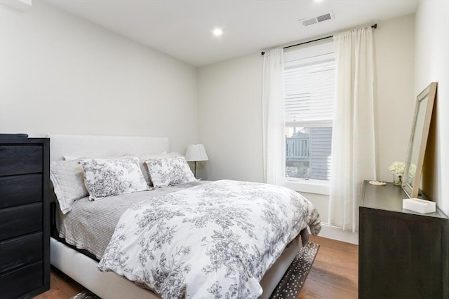 bedroom with wood finished floors, visible vents, and recessed lighting