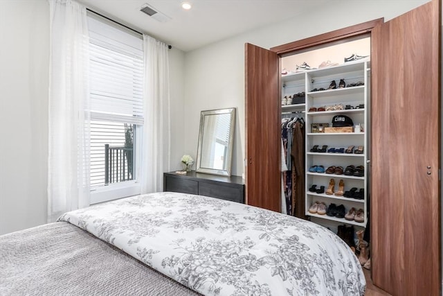 bedroom featuring visible vents, a walk in closet, and a closet