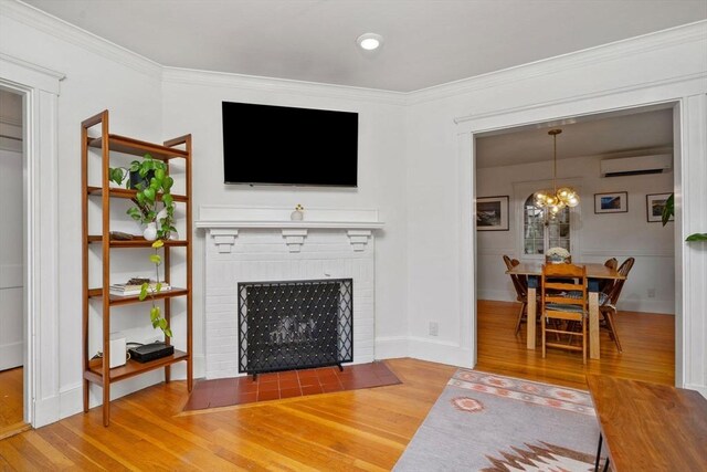 26 Edgebrook Rd, Boston, MA 02132 - living room featuring wood finished floors, a wall mounted AC, a brick fireplace, a chandelier, and crown molding