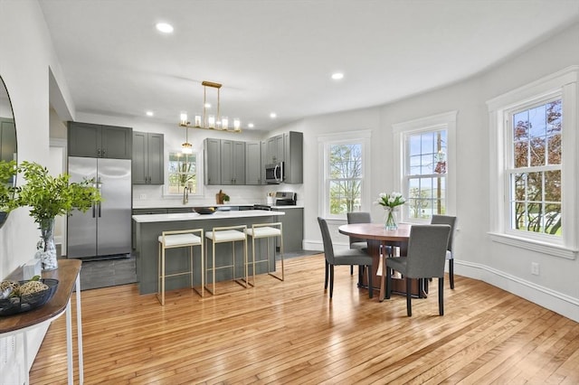 dining space featuring light wood finished floors, baseboards, and recessed lighting