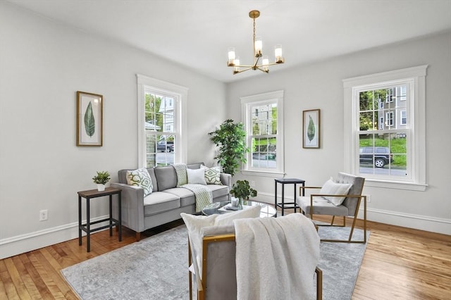 living area with a chandelier, wood finished floors, and baseboards