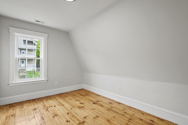 bonus room with baseboards, vaulted ceiling, and hardwood / wood-style flooring