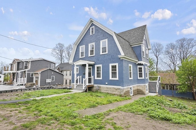view of front of house with a shingled roof and a gambrel roof