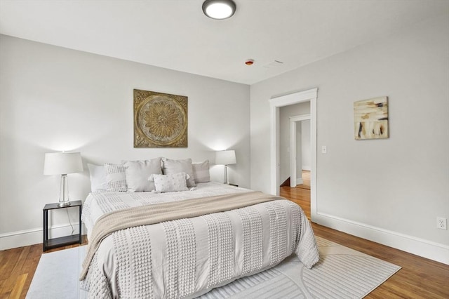 bedroom with baseboards and wood finished floors