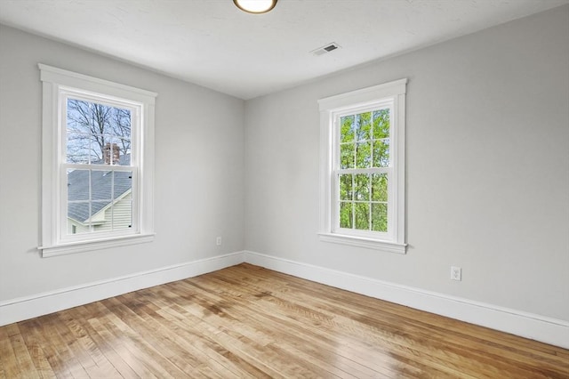 spare room featuring light wood finished floors and baseboards