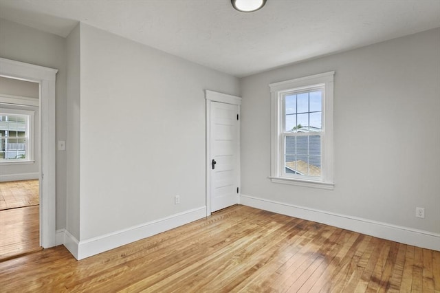 empty room with baseboards and light wood-style floors