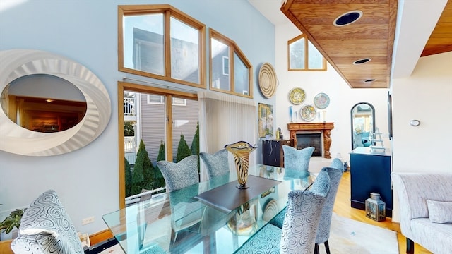 dining area with light wood-type flooring, high vaulted ceiling, and wooden ceiling