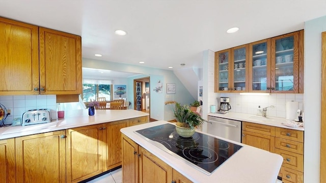 kitchen with a sink, stainless steel dishwasher, tasteful backsplash, light countertops, and black electric stovetop