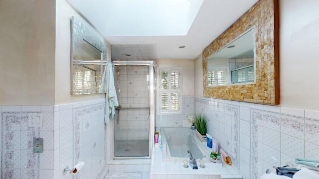 full bathroom featuring a garden tub, tile walls, and a stall shower