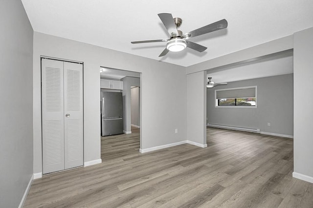 unfurnished living room with baseboard heating, light wood-type flooring, and ceiling fan