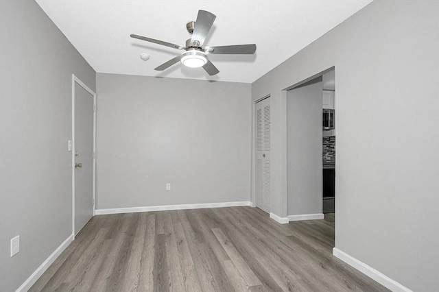 unfurnished bedroom with ceiling fan, light hardwood / wood-style flooring, and a closet