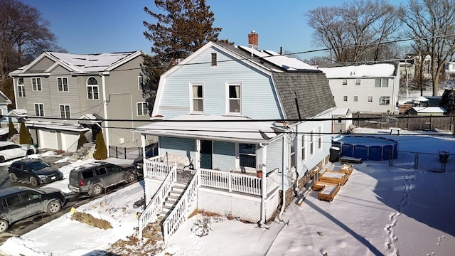 view of front of house with a swimming pool and covered porch