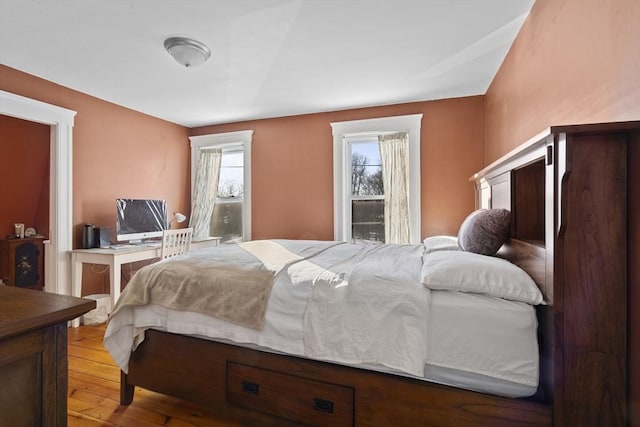 bedroom with multiple windows and light hardwood / wood-style flooring